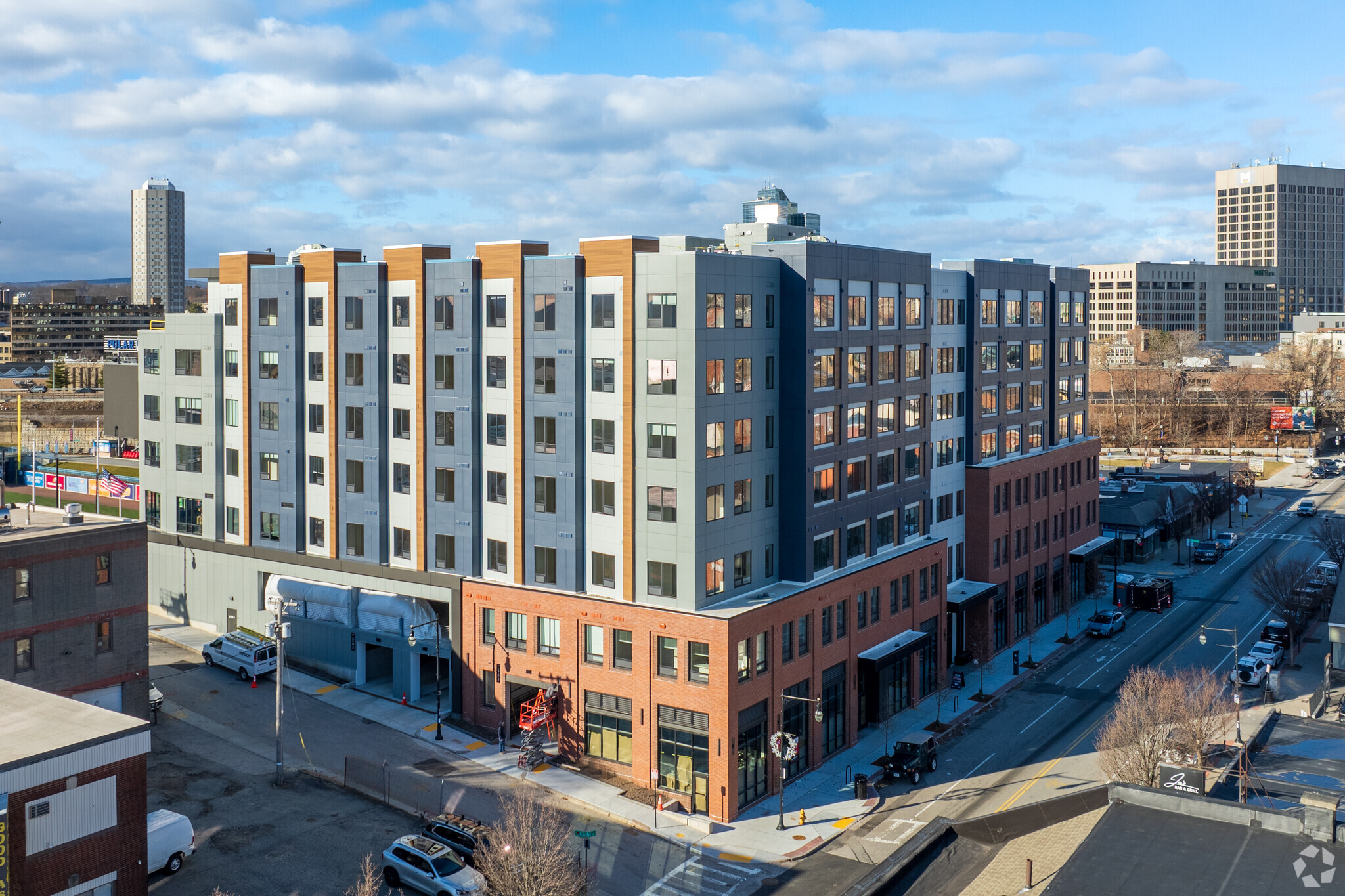 Corner view of The Cove apartment building in Worcester, MA, showing mixed brick and panel cladding.