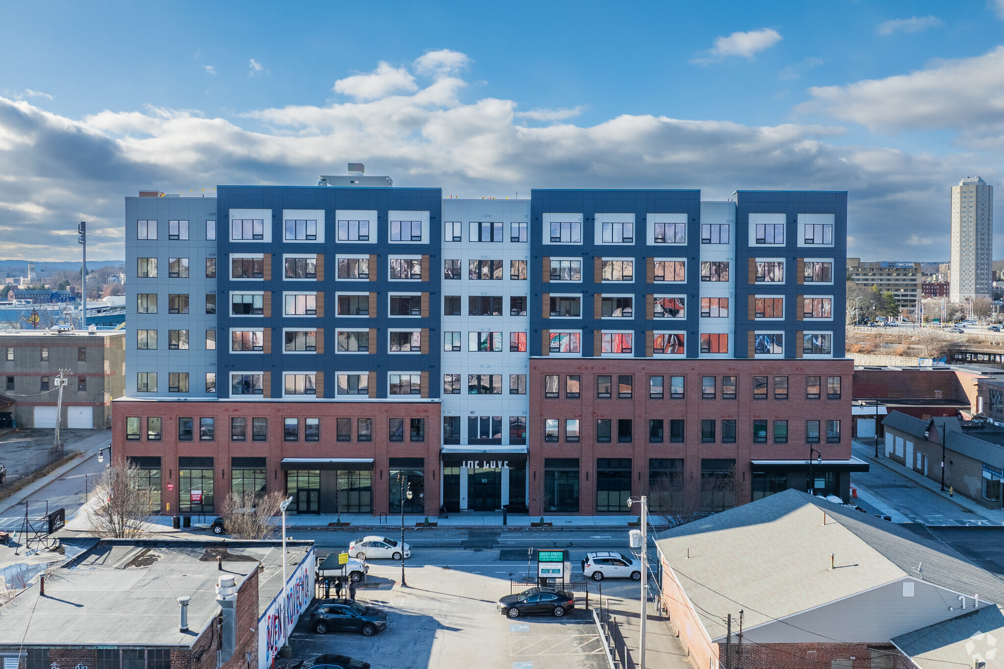 Straight-on elevation of The Cove in Worcester, MA, featuring large windows and red brick on the ground level.