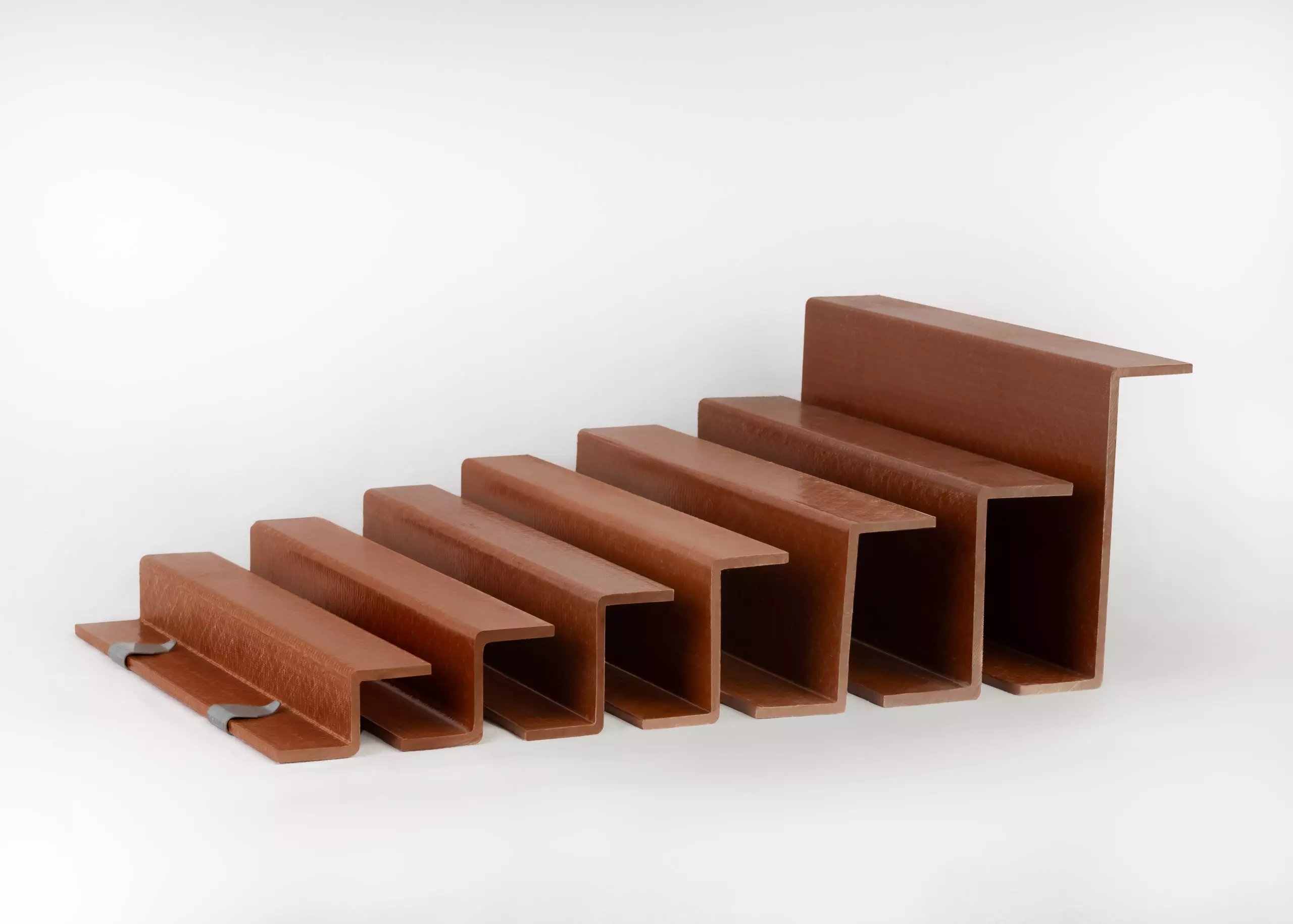 Line-up of Armatherm brown Z-girt thermal break profiles in various sizes, displayed against a white background.