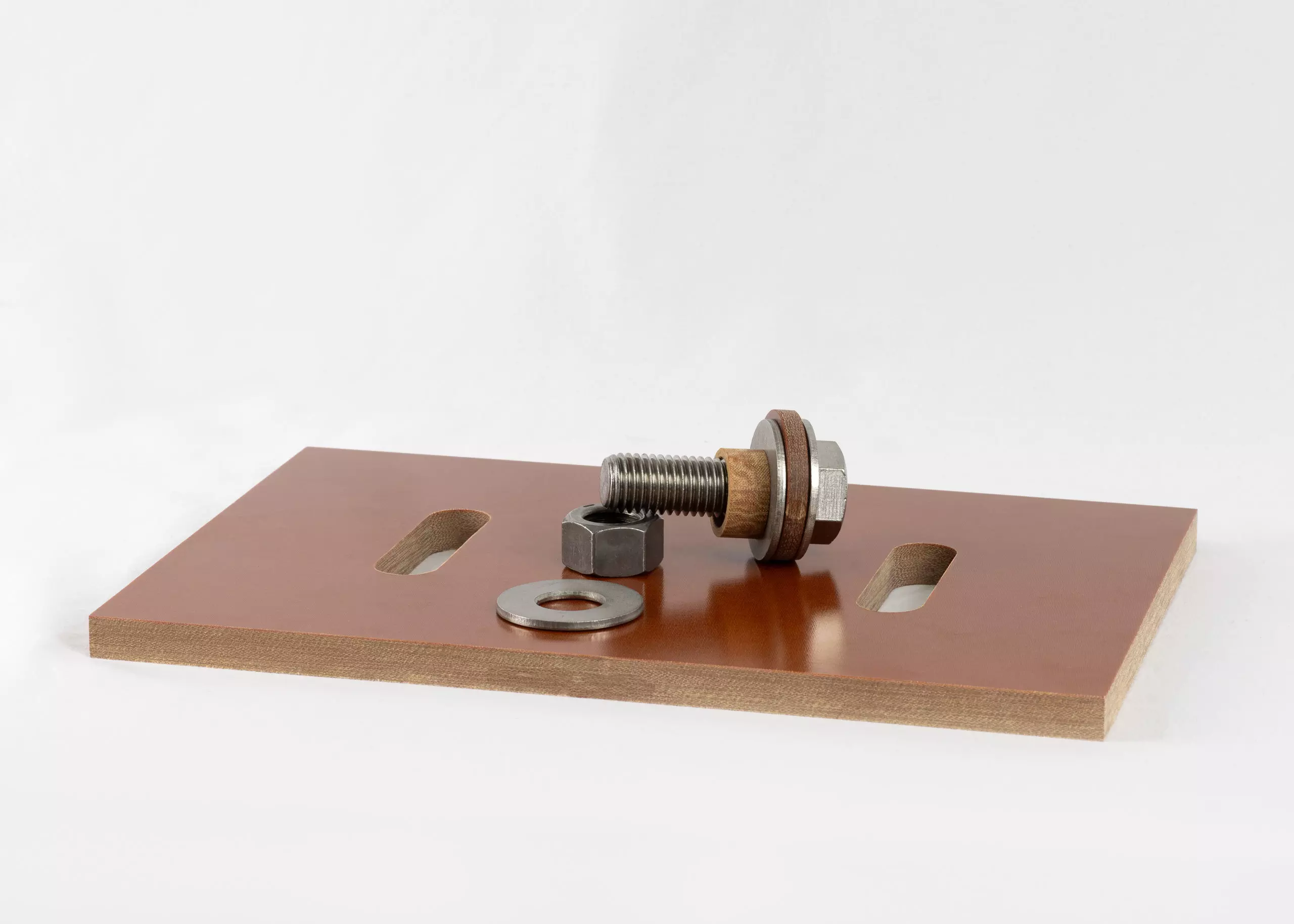 Armatherm FRR Thermal break plate with bolt, nut, washer, and isolation bushing shown on top of a brown insulation panel.