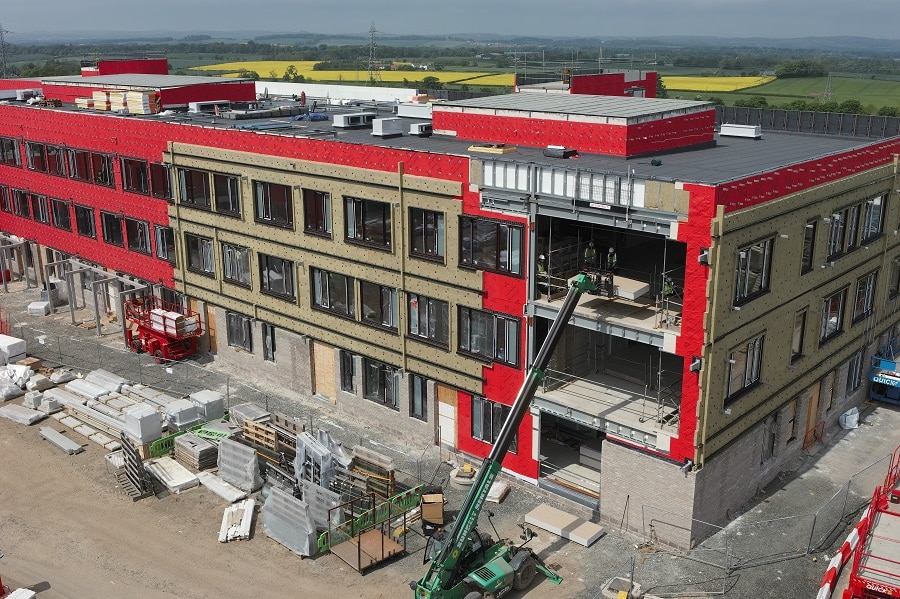 Aerial view of Currie Community High School under construction showing the high performance building envelope and structural framework where Armatherm 500 thermal breaks were specified at column base connections